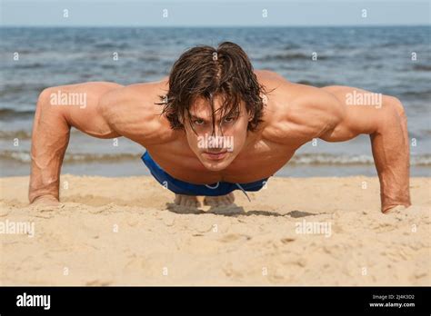 Muscular man during workout on the beach Stock Photo - Alamy