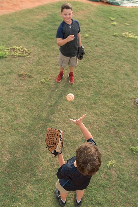 «Two Brothers Play Catch On A Baseball Field» del colaborador de Stocksy «Alison Winterroth ...