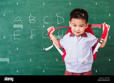 child boy from kindergarten in student uniform with school bag stand ...