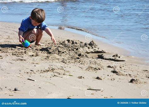 Child digging at the beach stock photo. Image of blue, water - 360606