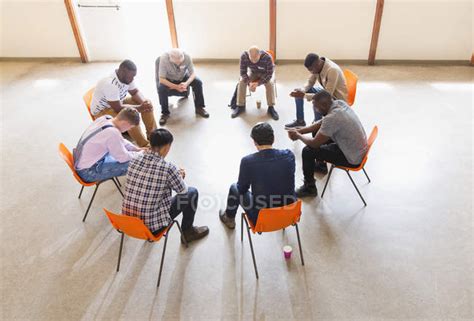 Men praying in circle in prayer group — chair, leaning - Stock Photo | #236029860