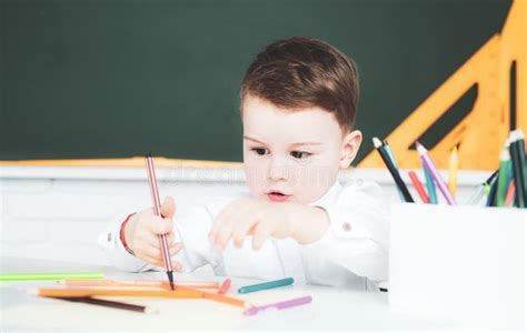 Kid Boy Writing in Classroom. Schoolboy Studying Homework during Her ...