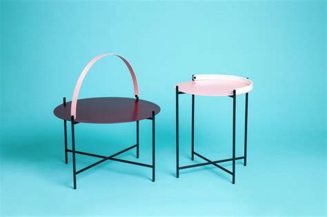two round tables with curved legs on each side, one pink and the other black