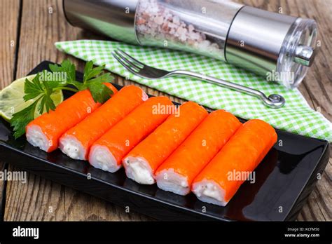 Surimi-crab sticks on black plate Stock Photo - Alamy