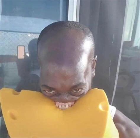 a man holding up a large yellow object to his face while looking at the ...