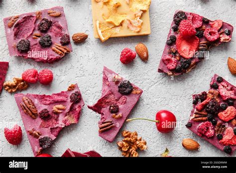 Handmade chocolate bars with fruits, berries and nuts on grey ...