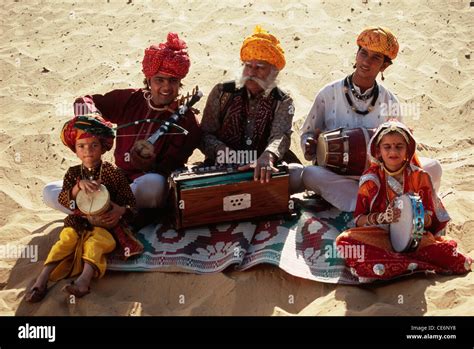 Indian folk musicians family playing musical instruments in desert ...