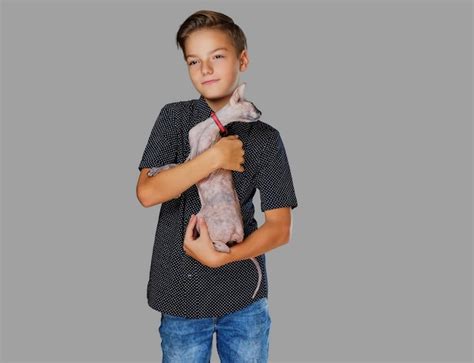 Premium Photo | Emotional little boy holds a cat. isolated on grey background.