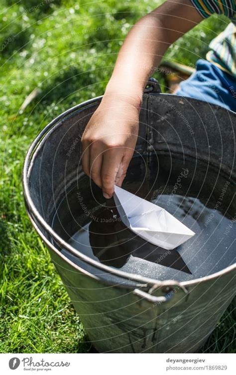 Child play with boat in a bucket of water - a Royalty Free Stock Photo from Photocase