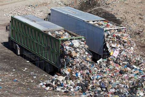 Trucks dumping waste in landfill - Stock Photo - Dissolve