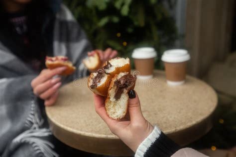 German Donuts - Berliner with Filling and Icing Sugar in Female Hands. Girls Enjoying Chocolate ...