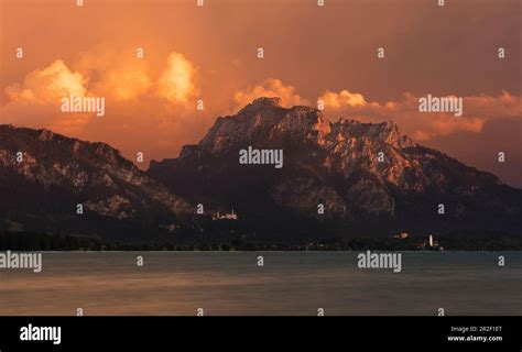 Neuschwanstein Castle and Hohenschwangau on Forggensee in the Ammer Mountains with clouds at ...