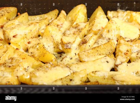 Roasted potatoes with spices and cheese Stock Photo - Alamy