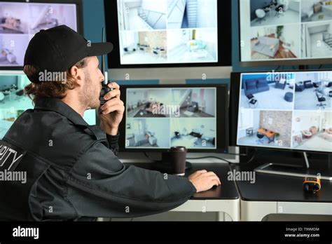 Security guard monitoring modern CCTV cameras in surveillance room ...