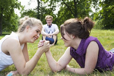 Teenage girls arm wrestling in grass - Stock Image - F004/4585 ...