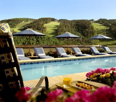 an outdoor swimming pool with lounge chairs and umbrellas over it's head area