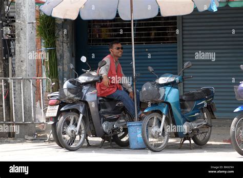 Motorcycle taxi driver in Thailand Stock Photo - Alamy