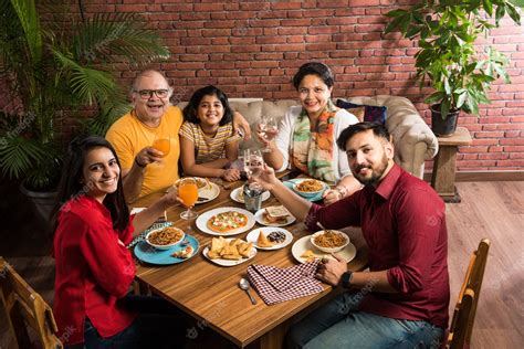 Premium Photo | Indian Family eating food at dining table at home or ...