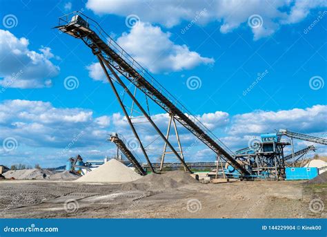 Conveyor Over Heaps of Gravel on Blue Sky at an Industrial Cement Plant. Stock Photo - Image of ...