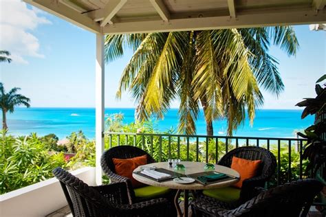 an outdoor dining area with wicker furniture overlooking the ocean