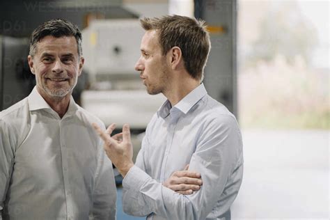 Two men talking in a factory stock photo