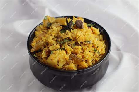 Premium Photo | Decorated veg biryani pulao in black bowl on a white cloth, made with rice and ...