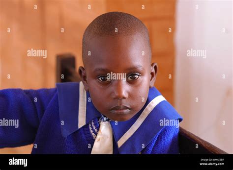 Nigeria, Jos, Portrait of a black child wearing a blue navy style shirt, at a wooden desk Stock ...