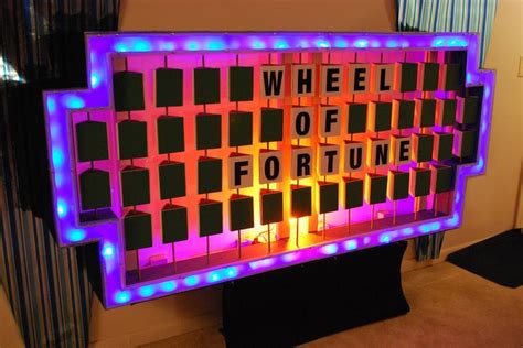 a wheel of fortune sign is lit up with blue and purple lights in the shape of squares