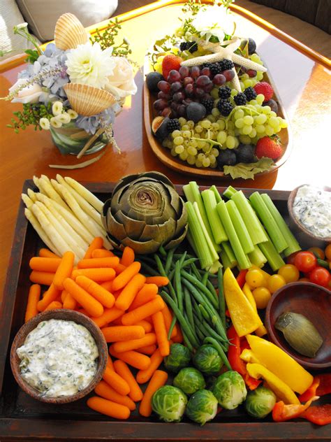 a tray filled with assorted vegetables and dips on top of a wooden table