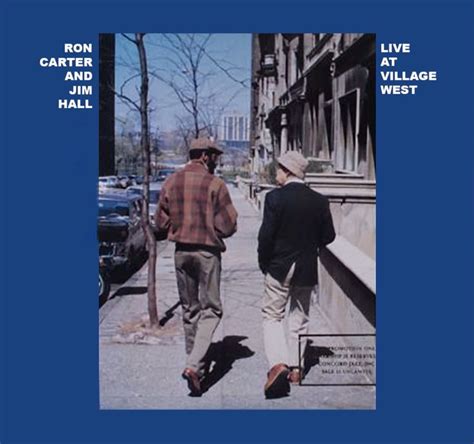 two men walking down the sidewalk in front of a blue sign that says ron carter and village hall