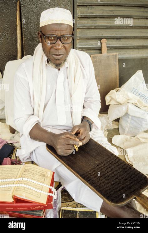 Bouake, Ivory Coast, Cote d'Ivoire. A Worshiper outside the Bouake Central Mosque with Koran ...