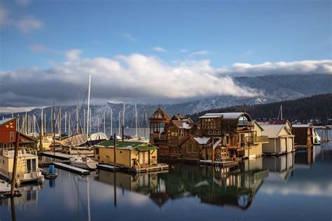 the boats are docked at the dock in the water with mountains in the backgroud