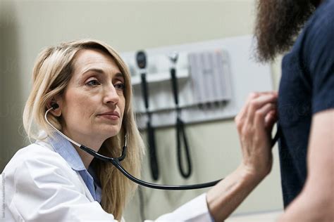 "Clinic: Doctor Uses Stethoscope To Check Patient" by Stocksy Contributor "Sean Locke" - Stocksy