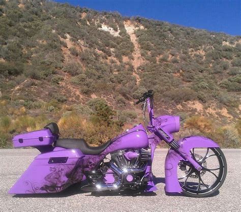 a purple motorcycle is parked on the side of the road