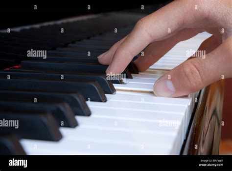 hand playing a chord on a grand piano Stock Photo - Alamy