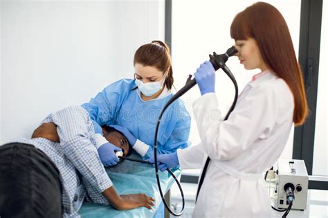 Female Concentrated Doctor Gastroenterologist, Operating Endoscope during Gastroscopic Procedure ...