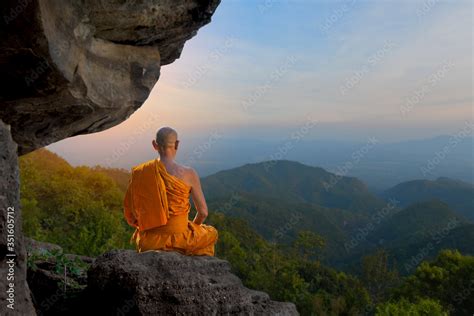 Buddhist monk in meditation Under the big stones in nature on high ...