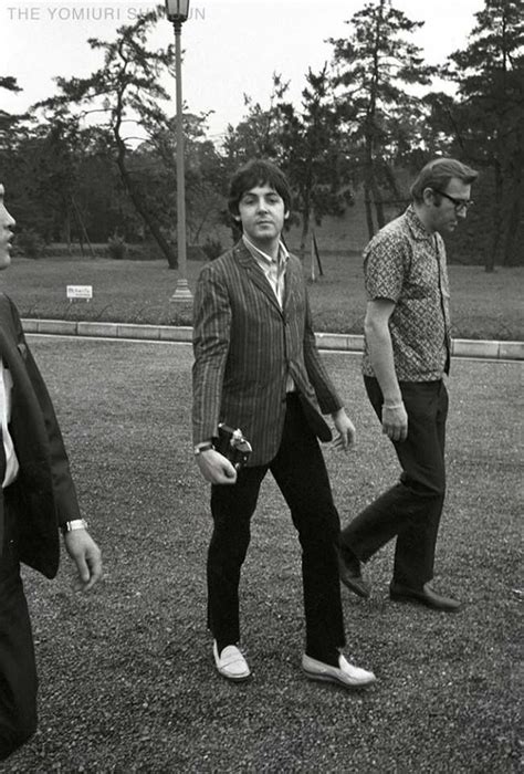 three men in suits are walking on the grass