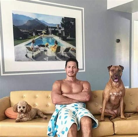 a man sitting on a couch next to two dogs