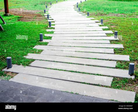 Curved concrete walkway with modern design pattern with garden lights ...