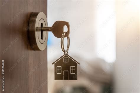 Open door to a new home with key and home shaped keychain. Mortgage ...