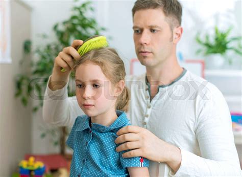 Father brushing hair of his daughter. | Stock image | Colourbox