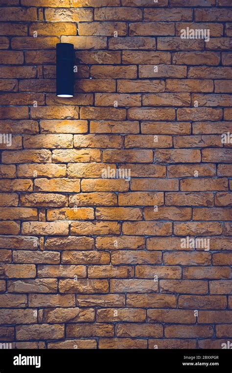 A section of a brown brick wall with an artificial light lamp Stock Photo - Alamy