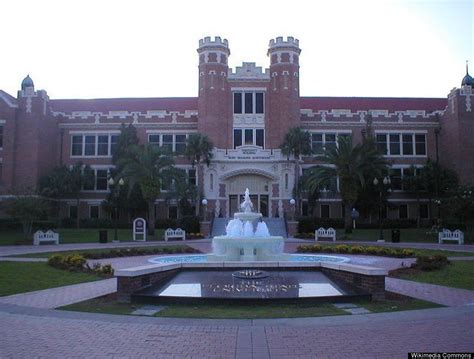 a large building with a fountain in front of it and palm trees around ...