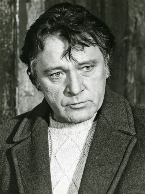 an old black and white photo of a man in a coat looking at the camera