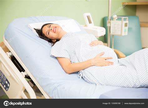 Woman getting labor contractions Stock Photo by ©tonodiaz 133095190