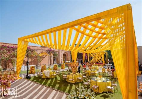 an outdoor wedding venue with yellow draping