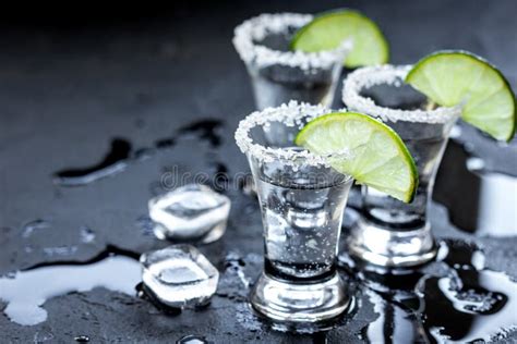 Silver Tequila Shots with Ice and Lime on Black Table Background Stock Photo - Image of gray ...