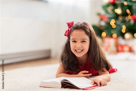 christmas, holidays and childhood concept - happy little girl lying on ...