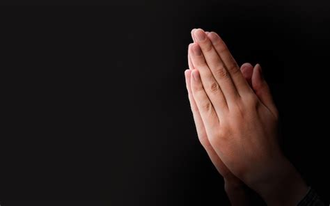 Premium Photo | Female hands praying on a dark background with copy space